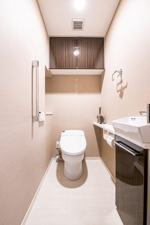 スタイリッシュなタンクレストイレ。温水洗浄機能、簡易手洗い場、収納棚付き