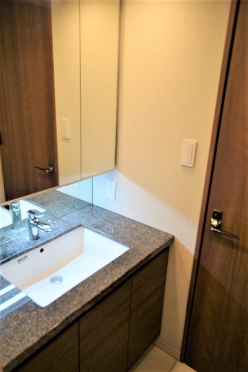 大理石タイルを使用した、3面鏡付きの洗面化粧台